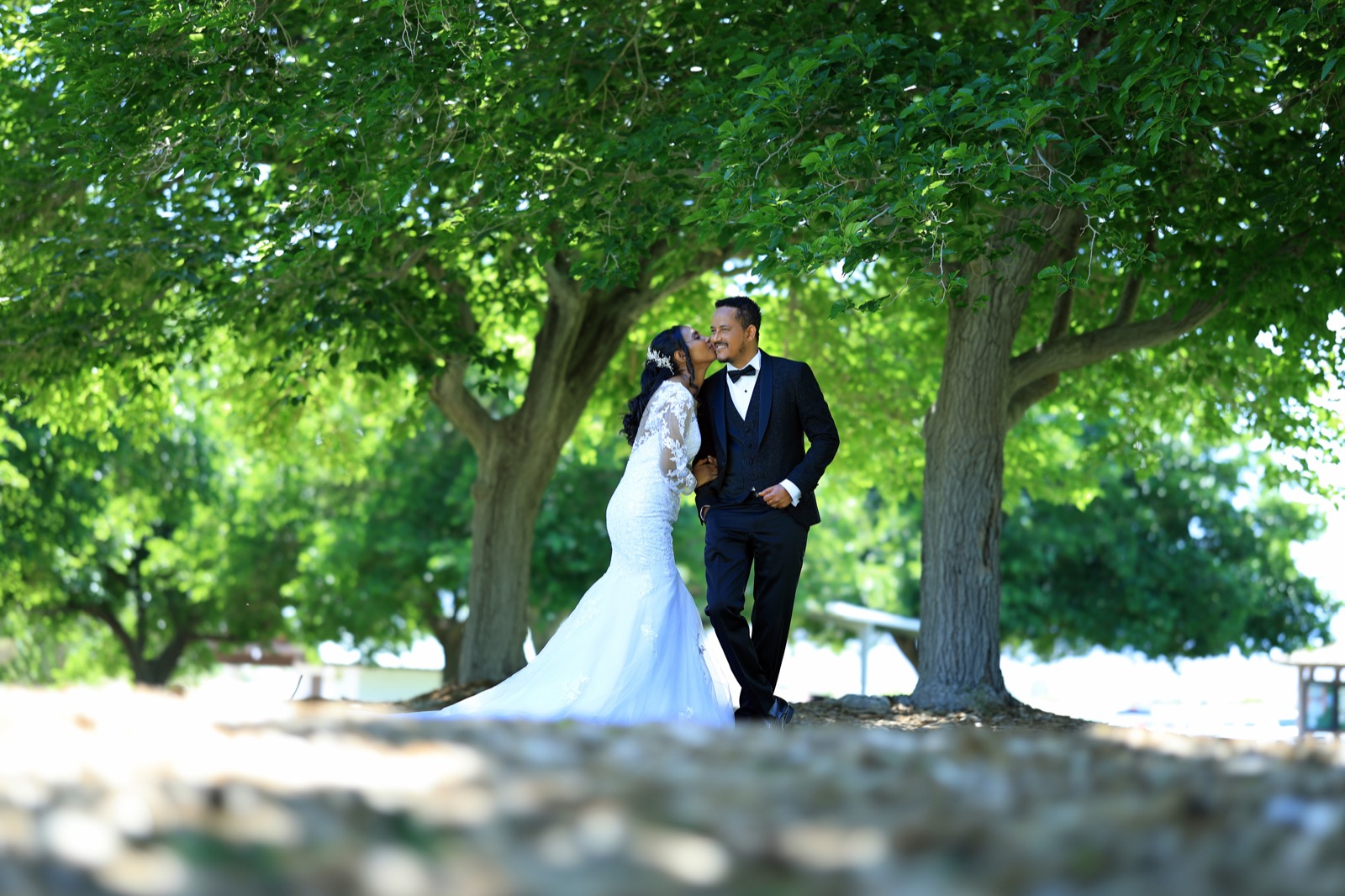 Bride and groom walking under trees